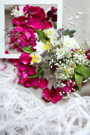 Floral arrangement with various beautiful flowers on a background of burlap and a white frame.の写真素材