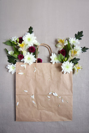 Floral arrangement with a paper bag, rope, natural fabrics.の写真素材