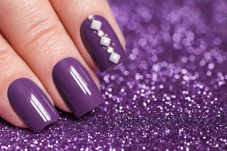 Female hand with purple nail design. Violet nail polish manicure.の写真素材