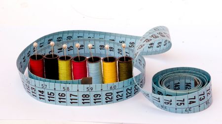 Measuring tape and spools of colorful threads isolated on white background