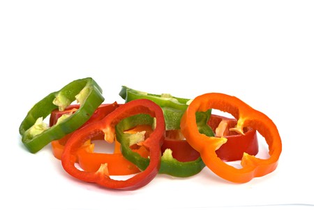 Longitudinal sections of green, yellow and red sweet peppers isolated on white background