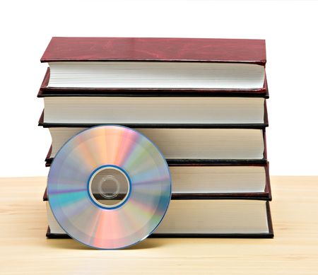 Pile of books  and DVD disk as symbols of old and new methods of information storageの写真素材