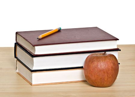 Red apple and pencil on top of booksの写真素材