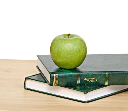 Green apple on books on deskの写真素材