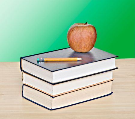 Red apple and pencil on top of booksの写真素材