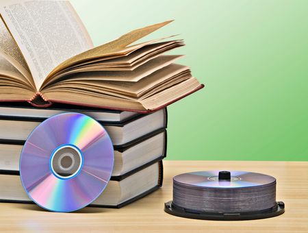 Pile of books  and DVD disk as symbols of old and new methods of information storageの写真素材