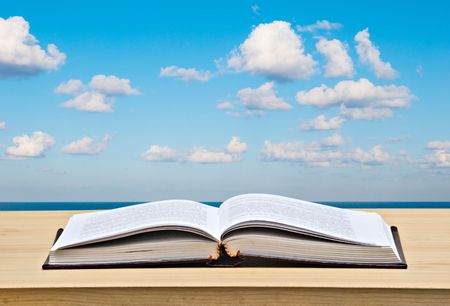 Open book on desk and seaの写真素材