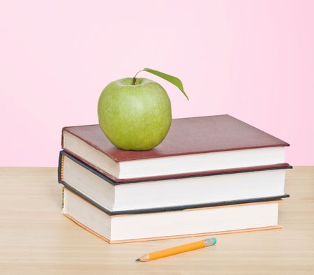Red apple and pencil on top of booksの写真素材