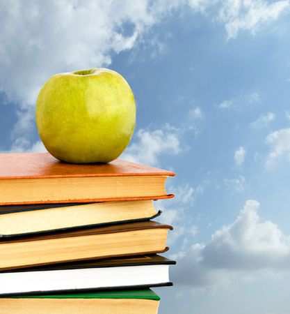 Green apple on pile of books の写真素材