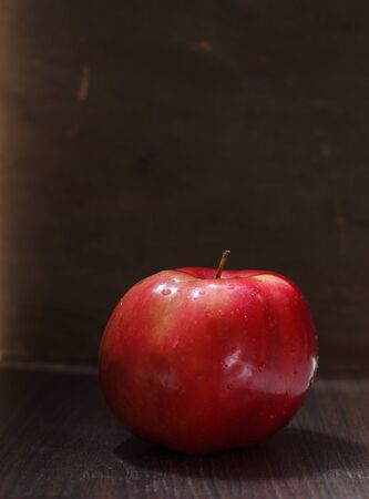 One red apple with a handle on a dark backgroundの写真素材