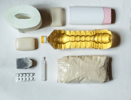 flatlay of toilet paper, tablets, soap, oil and tea on a light background