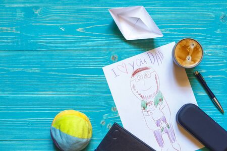 A child's drawing of a father and son on a blue table along with man's accessories and children's...