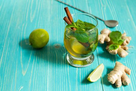 Detox cocktail with lime, ginger and mint in a glass on an aquamarine background, horizontally with spaceの写真素材