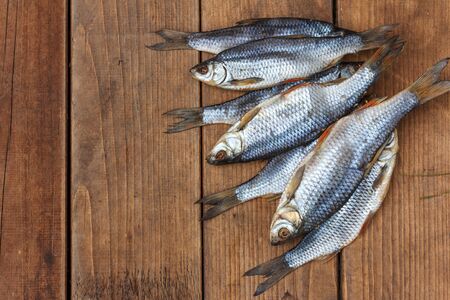 Salted roach, a traditional fish from Astrakhan on dark wooden boards, top view with space