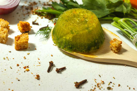 Frozen green broth with vegetables and seasonings close-up, cooking ingredients in the backgroundの写真素材