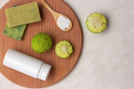 natural green soap from osage orange fruit, cream bottle and maclura fruit on a wooden Board, top viewの写真素材