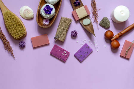 Layout of colored natural soap and items for Spa treatments. Top view on a lilac background with spaceの写真素材