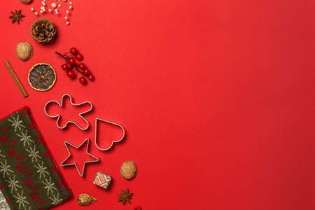 Layout for a new year or Christmas card on red paper, with cookie cutters, nuts and decorations for...