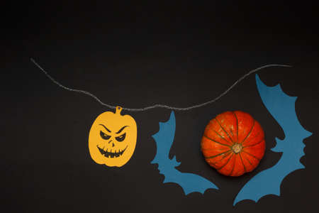 Background for Halloween. pumpkin with a creepy face and bats drawn from colored paper. On a black...
