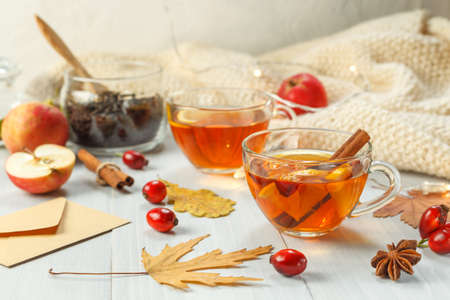 Two cups of fragrant tea with rosehip, lemon and spices. A healthy drink to strengthen the immune system. On a light wooden background, close-upの写真素材