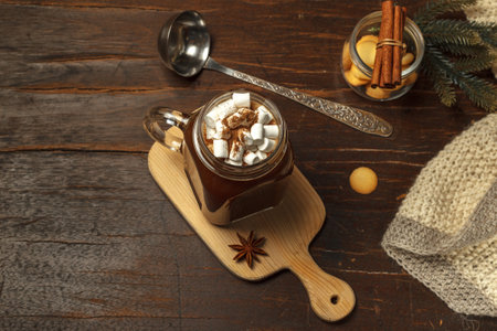 Flatlay with a Cup of hot chocolate and marshmallows, on a dark wooden table with fir branches and a knitted blanket. Concept of a winter drink, Christmas evening. Top view with spaceの写真素材