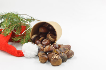 Roasted chestnuts, a traditional winter and autumn appetizer. You can take chestnuts for a walk in a paper Cup. Isolate with Christmas accessoriesの写真素材