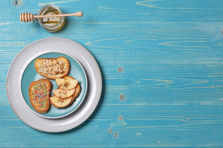 French toast with apple slices, honey and cinnamon on a blue plate. top view on blue wooden background with spaceの写真素材