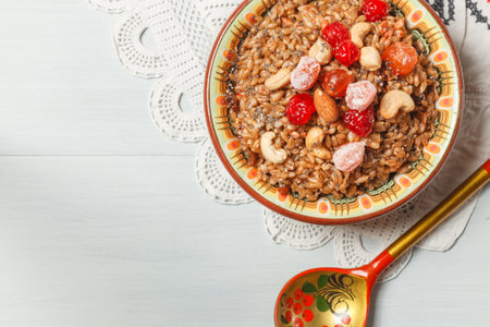 spelt porridge with nuts, honey and candied fruits. in a ceramic bowl on a linen napkin with embroidery. lean, vegetarian dishの写真素材