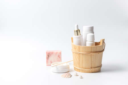 Cosmetics for spa care without labels in a wooden stand. On a white background, with spaceの写真素材