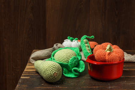 A toy set of vegetables. Amigurumi vegetables for soup. Handmade knitted toys. Low key.の写真素材
