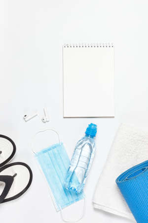 Sports training during a pandemic is about taking care of yourself and others. Spend a workout at home or. or take a mat, bottled water, protective mask, and sanitizer to the gym.Sports and protective accessories on a white backgroundの写真素材