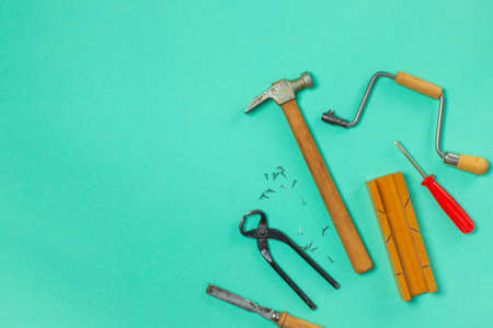 Vintage carpentry tools on a green background. screwdriver, ruler, hammer, pliers, chisel, hand saw...