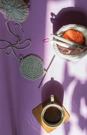 The concept of time for hobby, leisure, needlework ,. Crocheting in gray cotton yarn, coffee in a...