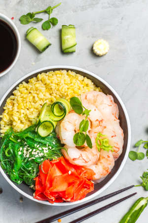 Poke, a Hawaiian dish.Bulgur, shrimp, chuka lettuce, and pickled ginger. Top view, close-up on a...