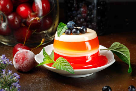 Multi-layered Panna cotta with cherry jelly. A delicious, healthy dessert based on cream and berry juice. Close-up, low key.の写真素材
