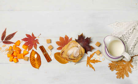Autumn concept, background. Bright autumn leaves on a gray wooden background, pumpkin sinabon, a jug...