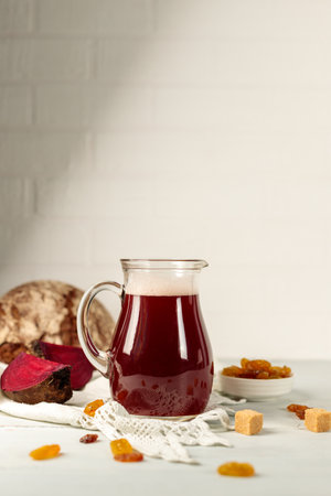 Beet kvass, a natural refreshing fermented drink. Normalizes digestion, quenches thirst. A jug with a drink on a light backgroundの写真素材