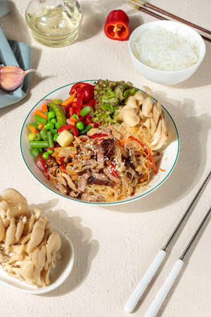 Chapche, a festive dish of Korean cuisine. Funchosa with vegetables, beef and mushrooms. Close-up on...