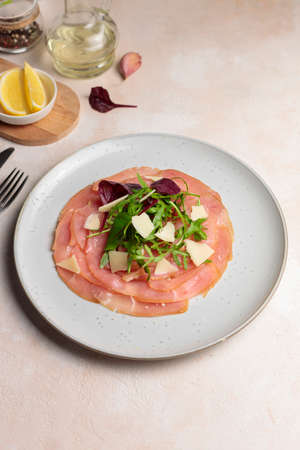Carpaccio with mixed salad and parmesan. Close-up, with ingredients for cooking. Verticalの写真素材