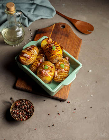 natural organic food. Potatoes in the skin, baked with ham, cheese, herbs and spices. Vertical frame, close-up.の写真素材