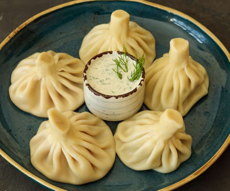 Khinkali on a plate with sauce. Close-up. Georgian national dishの写真素材