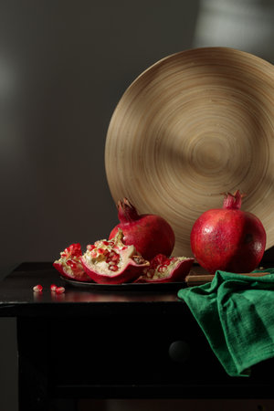 Still life with pomegranates and green drapery. Vertical, low keyの写真素材