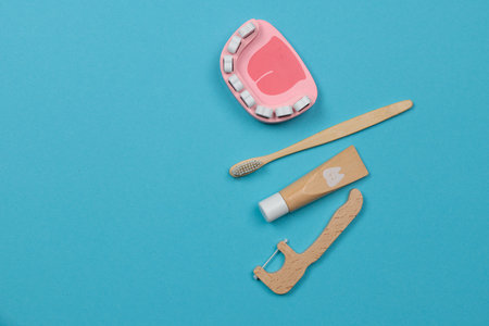toy dental instruments and a mock-up of a jaw with teeth. Top view on a blue background.