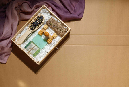 A gift set of eco-friendly products for skin and hair care. Dry shampoo, natural washcloth, wooden comb. On a craft background, with spaceの写真素材