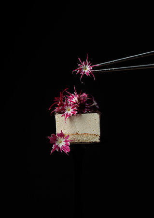 Cake, Dessert decorated with edible flowers. Vertical frame on a black background. with metal...