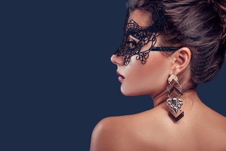 Beautiful brunette model wearing lace carnival mask and jewellery. New year party.の写真素材