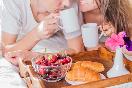 Couple in love having breakfast in bedの写真素材