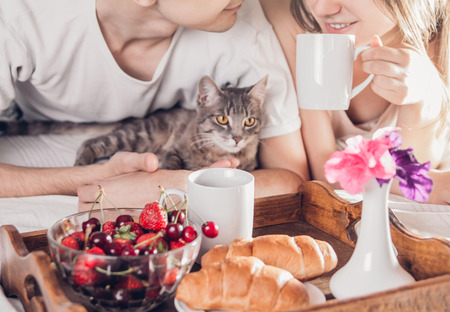 Couple in love having breakfast in bedの写真素材