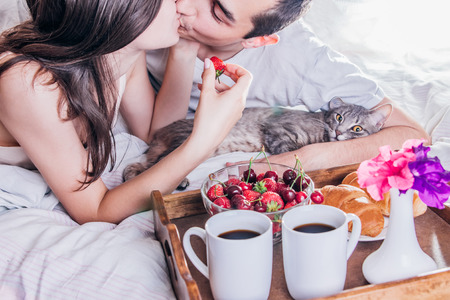 Couple in love having breakfast in bedの写真素材