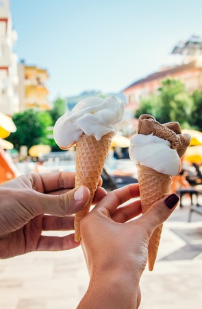 Couple holds vanilla ice-cream outside the hotel